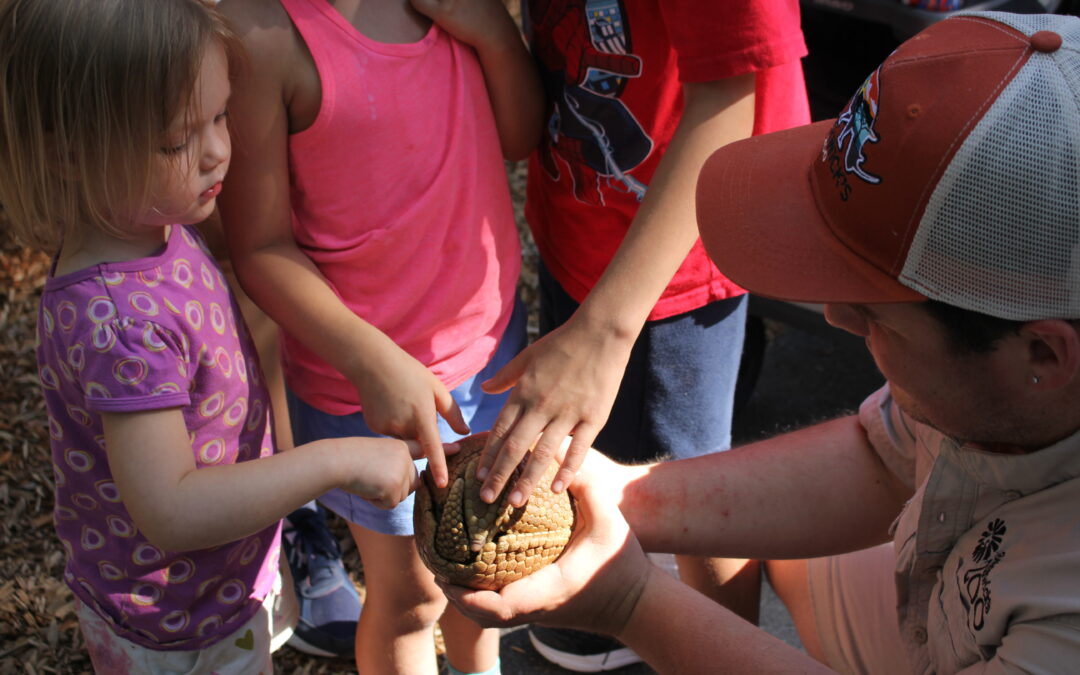 Derrick Silva showing the three band armadillo to a group of children on a ZooMobile trip.